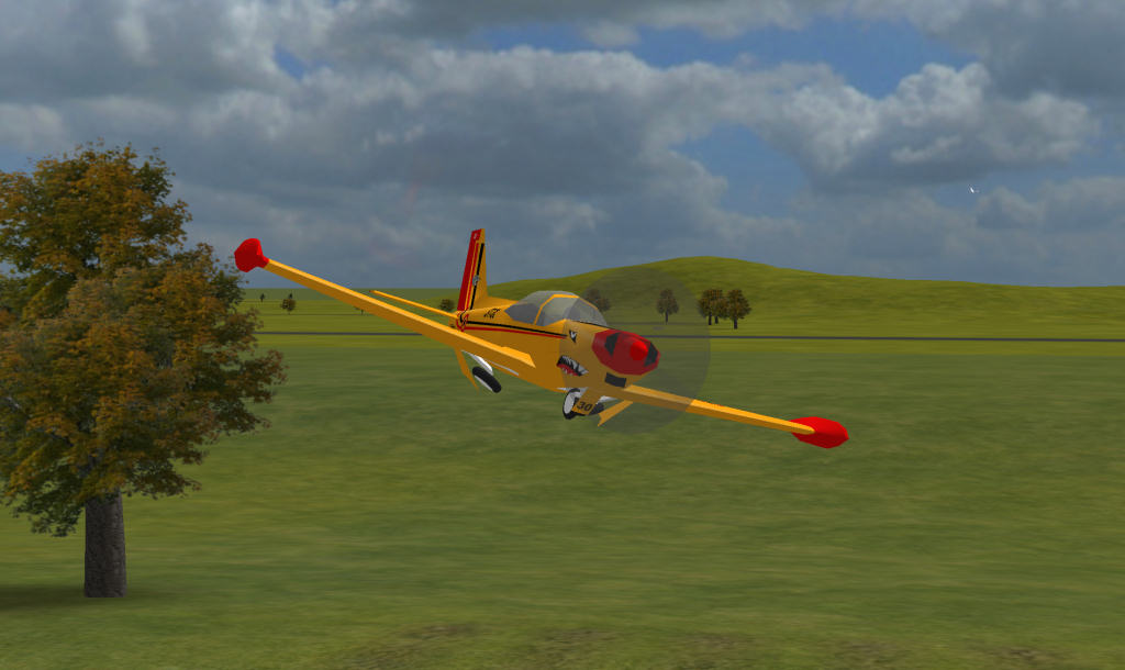 R/C Desk Pilot showing a yellow and red powered model in flight over a field